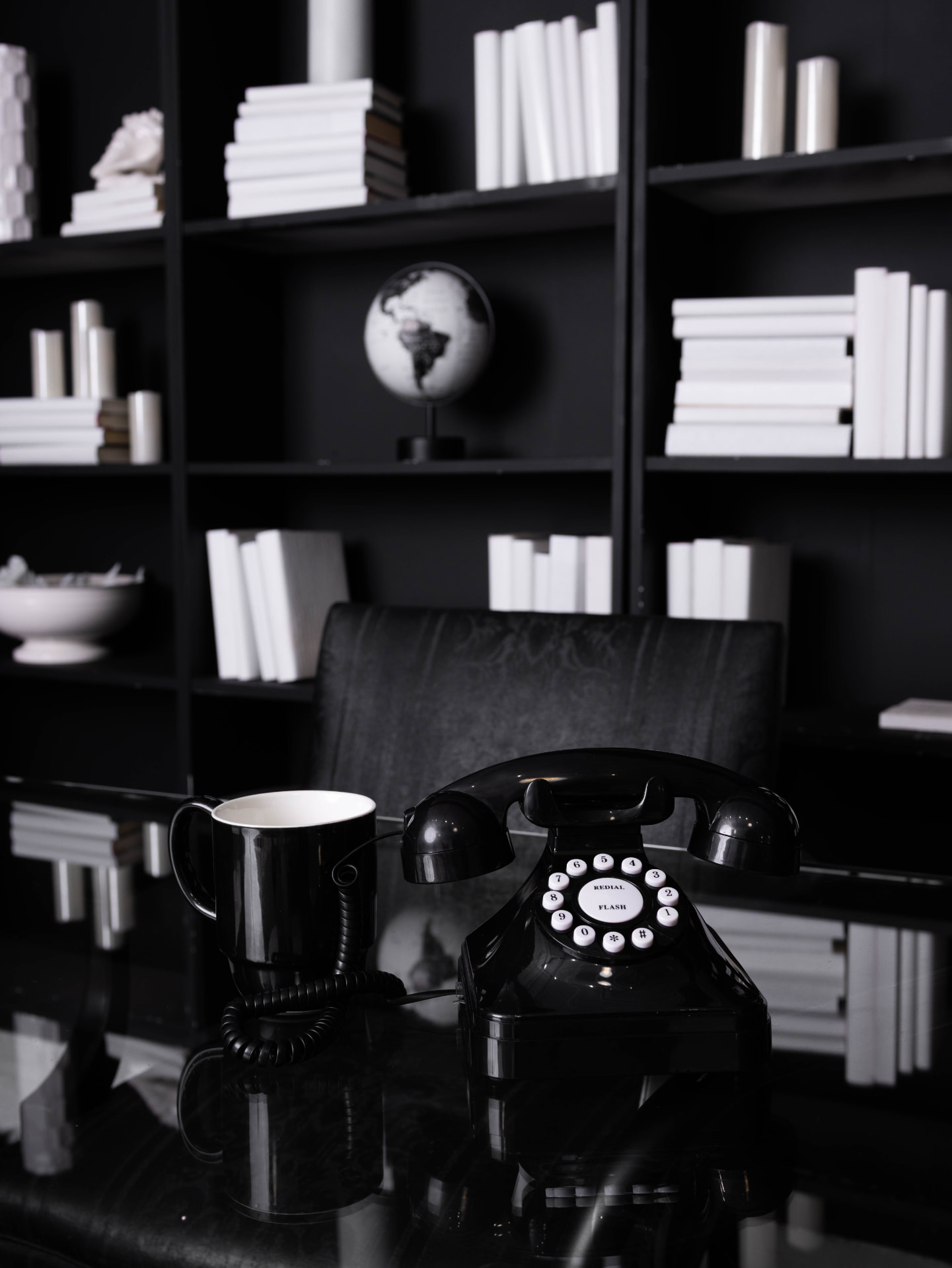 Moody black office set at The Hutch Studio with a vintage telephone and white books