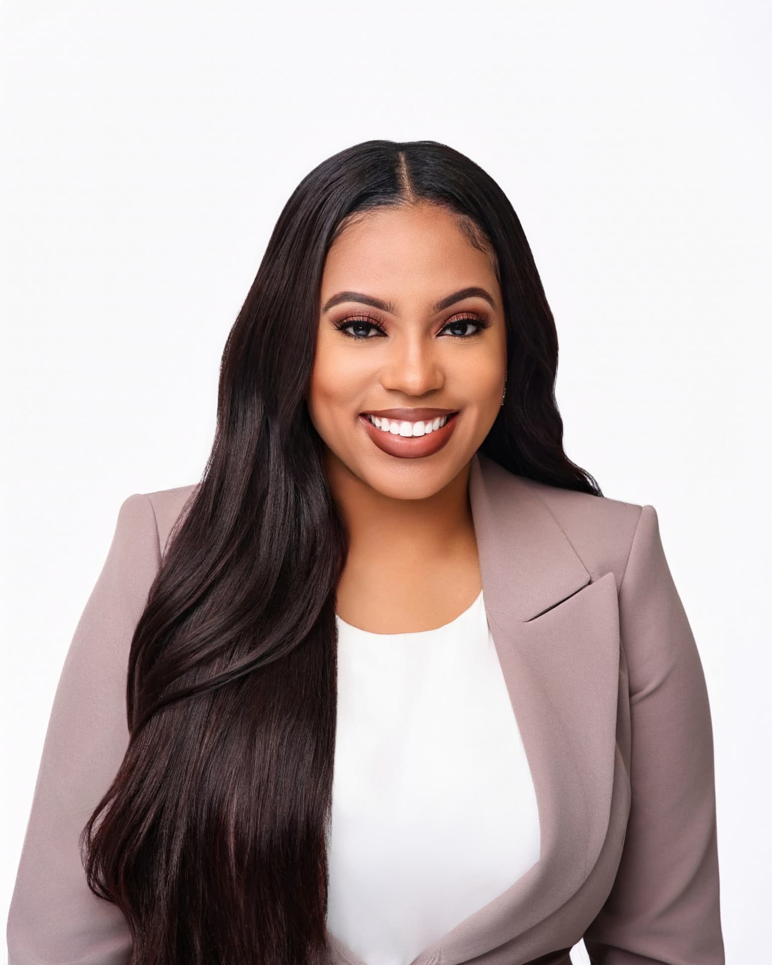 Smiling headshot in a mauve blazer on a white backdrop