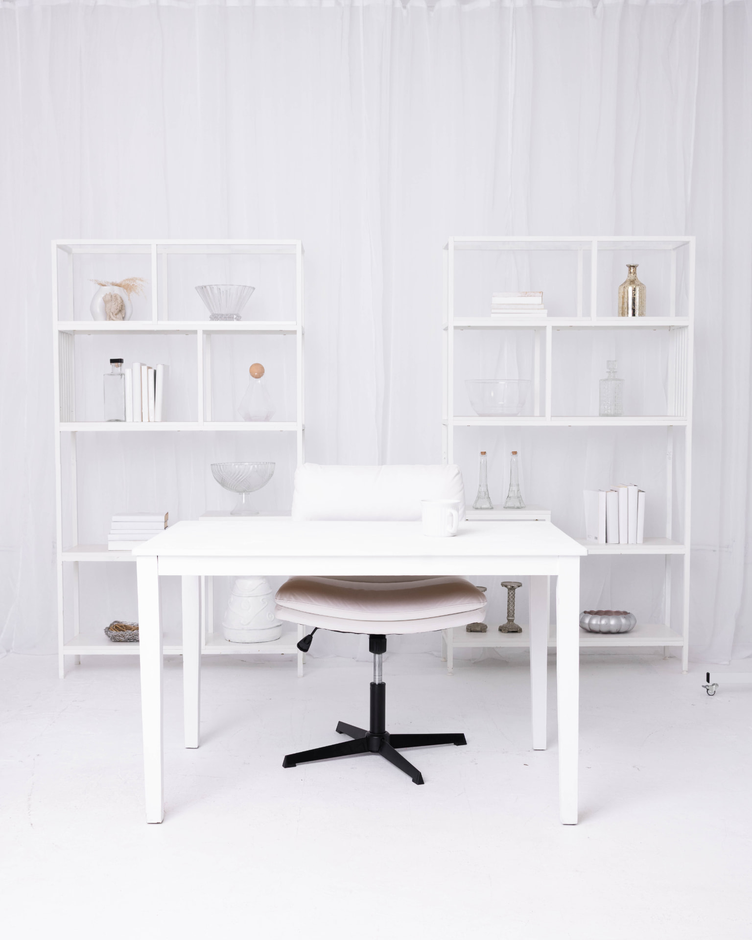 All-white office set at The Hutch Studio with shelves, desk and chair