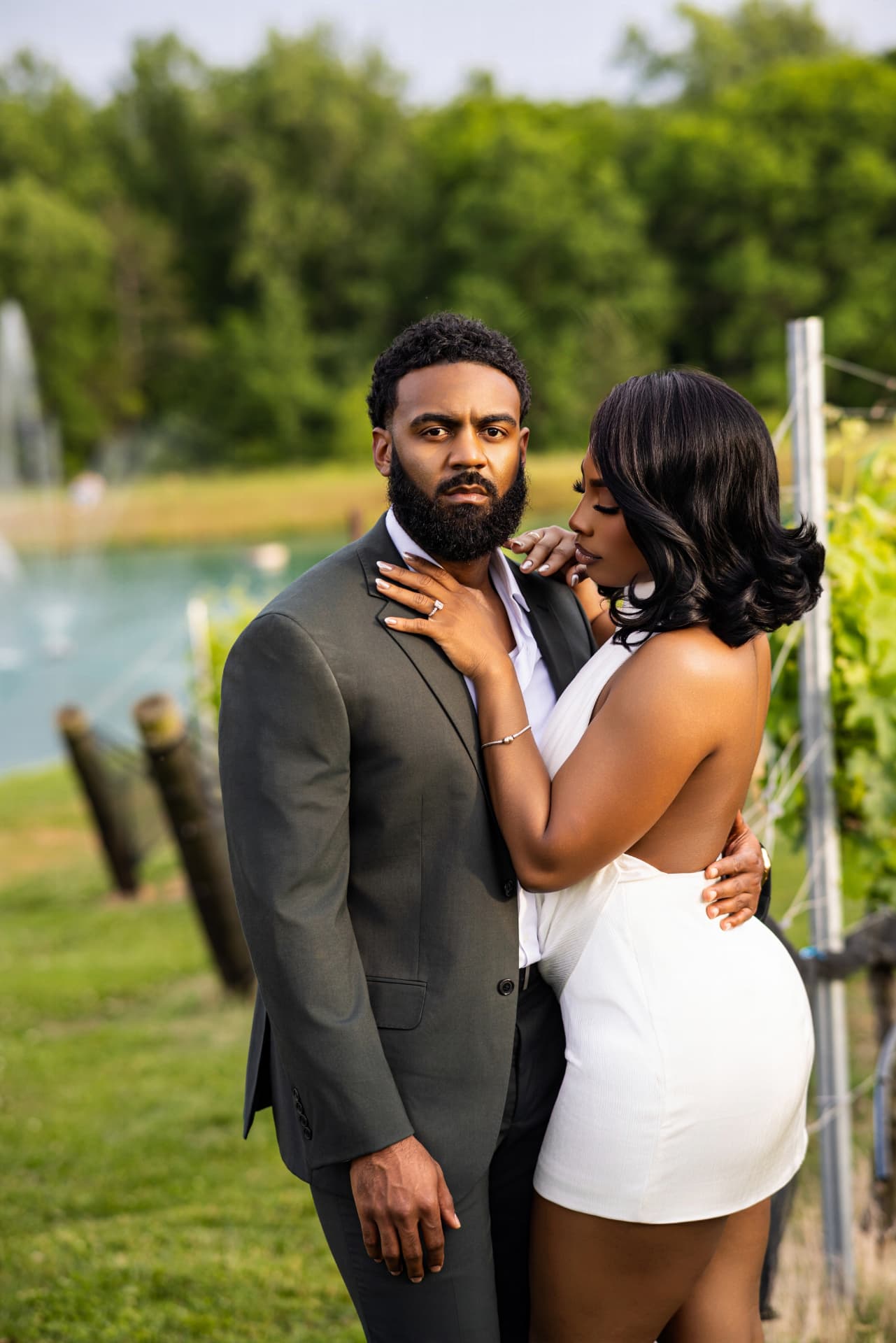 Couple posing close together in the vineyard, her hand on his chest