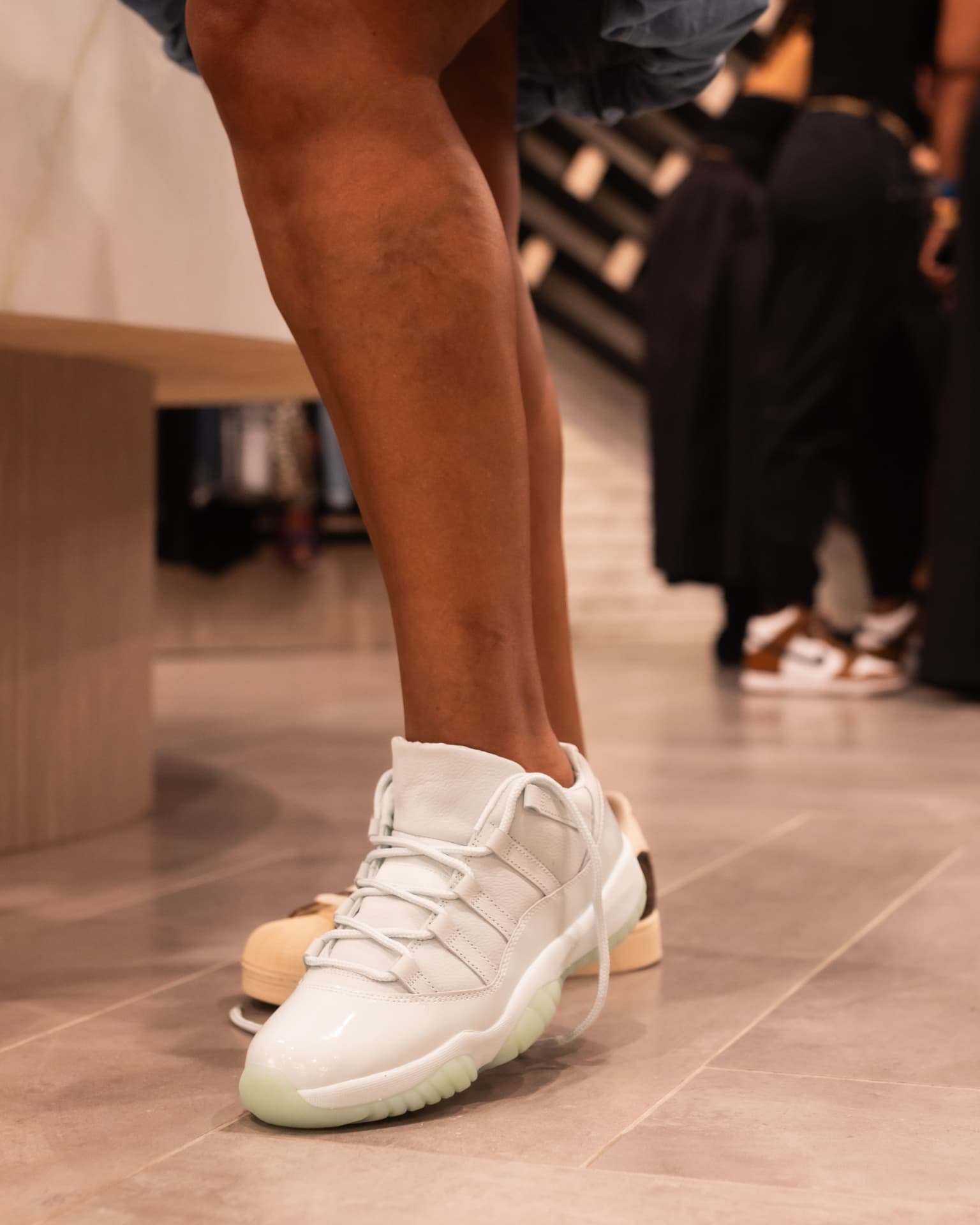 Close-up of white sneakers on the gallery floor