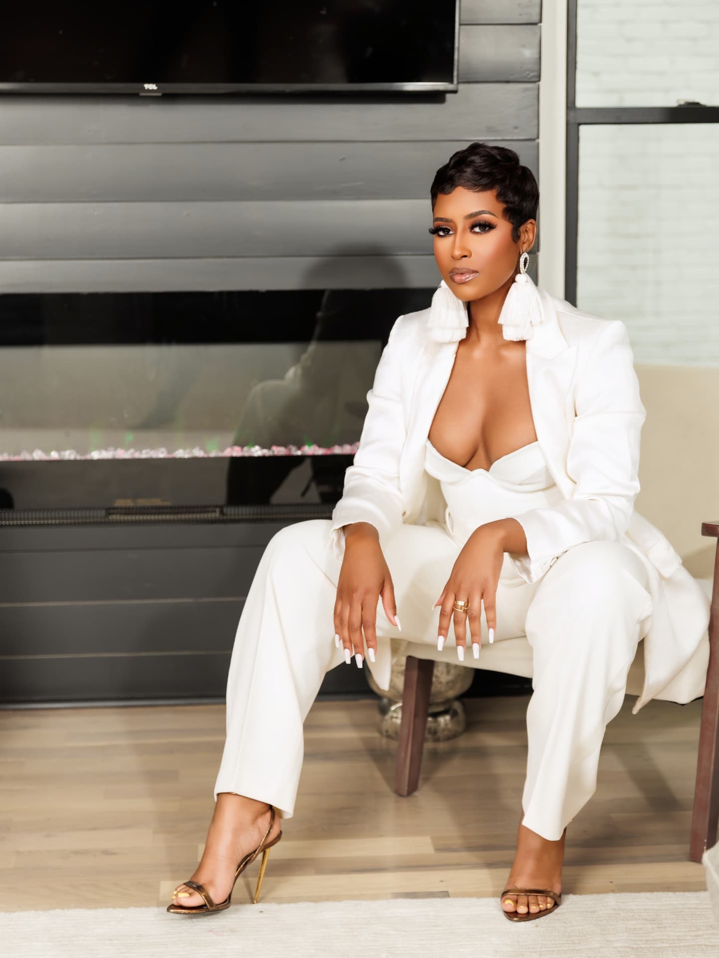Client seated in a white suit by a fireplace