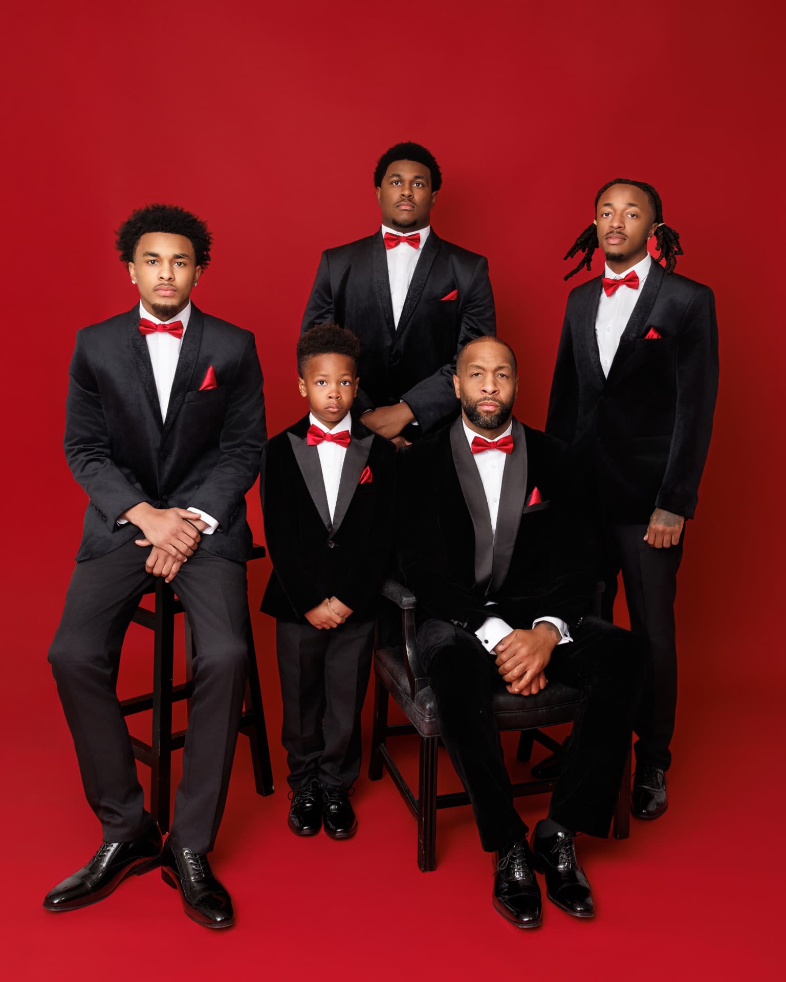 Father and four sons in tuxedos with red bow ties